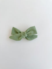 Green bow hair clip on a white background