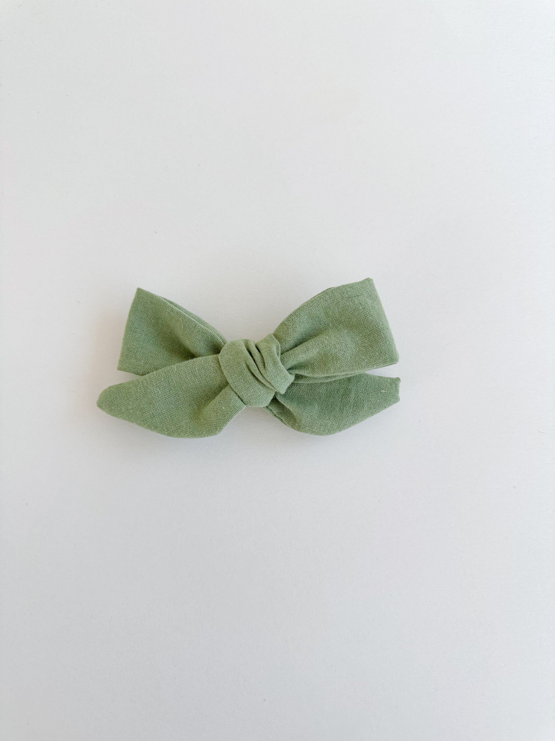 Green bow hair clip on a white background